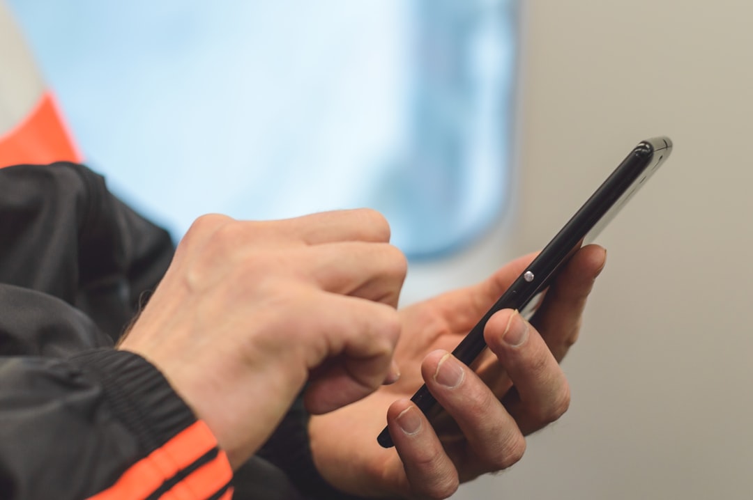 person in black and orange long sleeve shirt holding black pen person in black and orange long sleeve shirt holding black pen