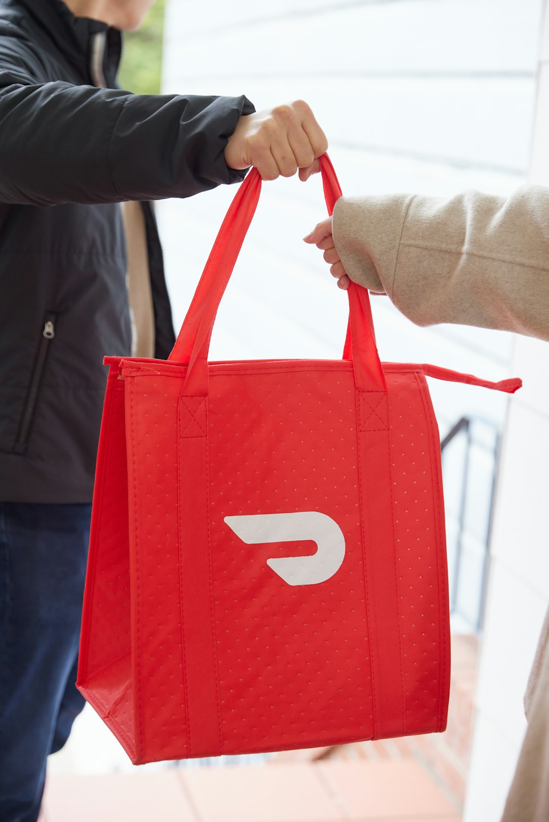 a person holding a red bag with the letter D on it a person holding a red bag with the letter D on it