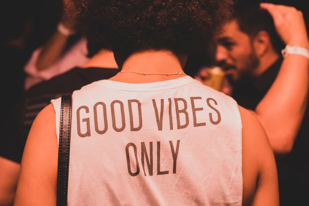 photo of person wearing white and brown good vibes only shirt photo of person wearing white and brown good vibes only shirt